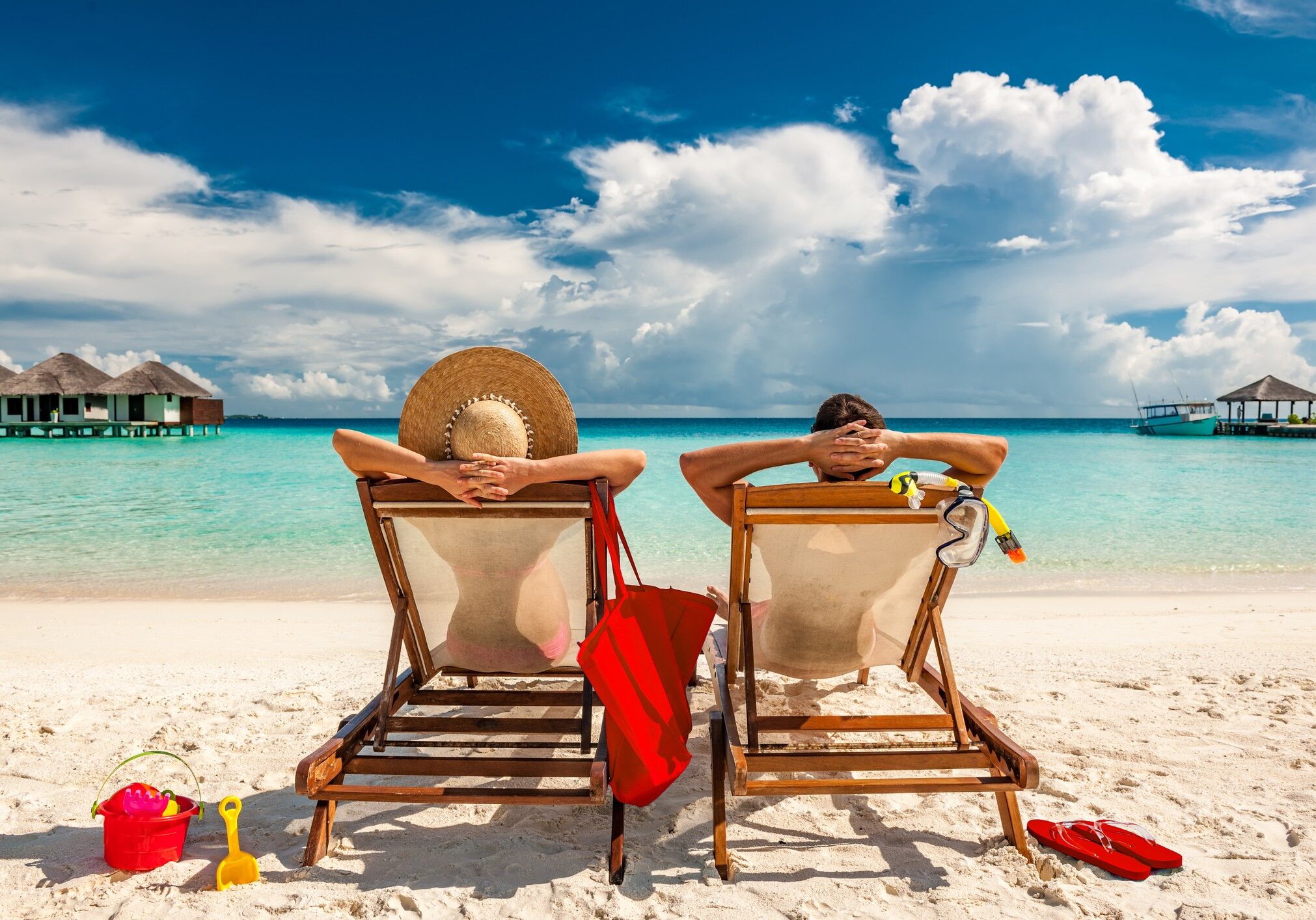 Couple in loungers on a tropical beach at Maldives